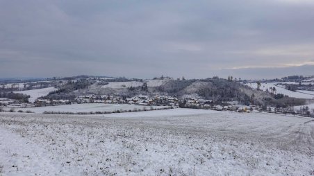 Výhled jihovýchodním směrem na obec Pokojovice z vrcholu kopce Šibeník (578)