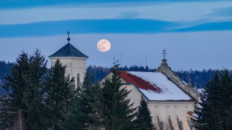 Měsíc v úplňku nad kostelem Nejsvětější Trojice v osadě Klášter I